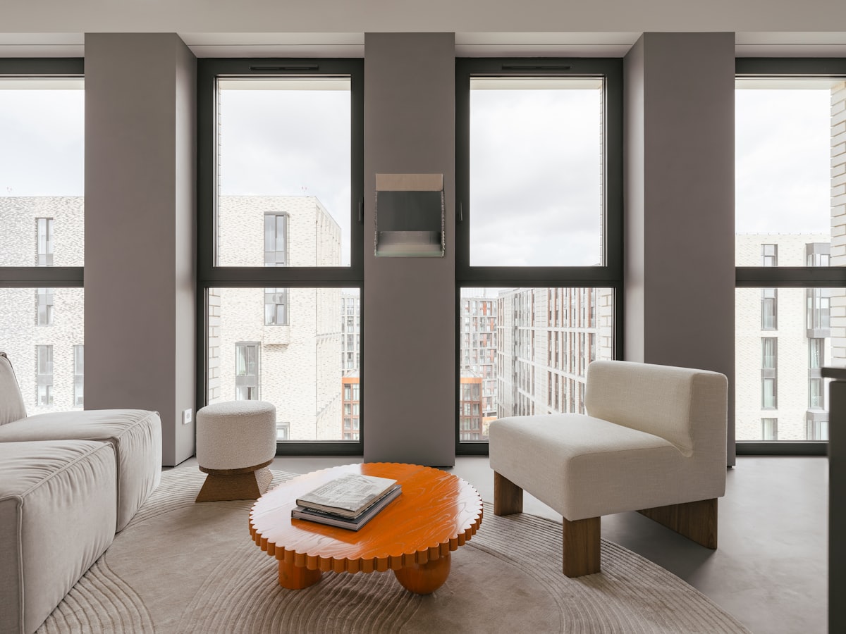 Modern eingerichtetes Wohnzimmer mit großen Fenstern